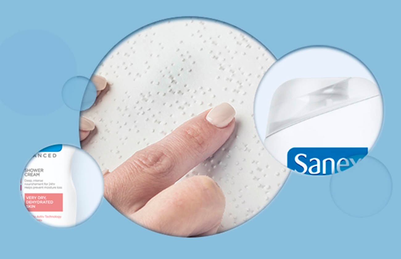 a woman's finger touching a braile, with a sanex logo on the right and a sanex benfits icon on the left