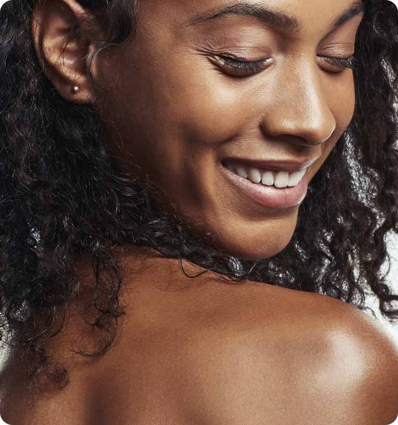 Woman smiling with her eyes closed and her back skin showing 