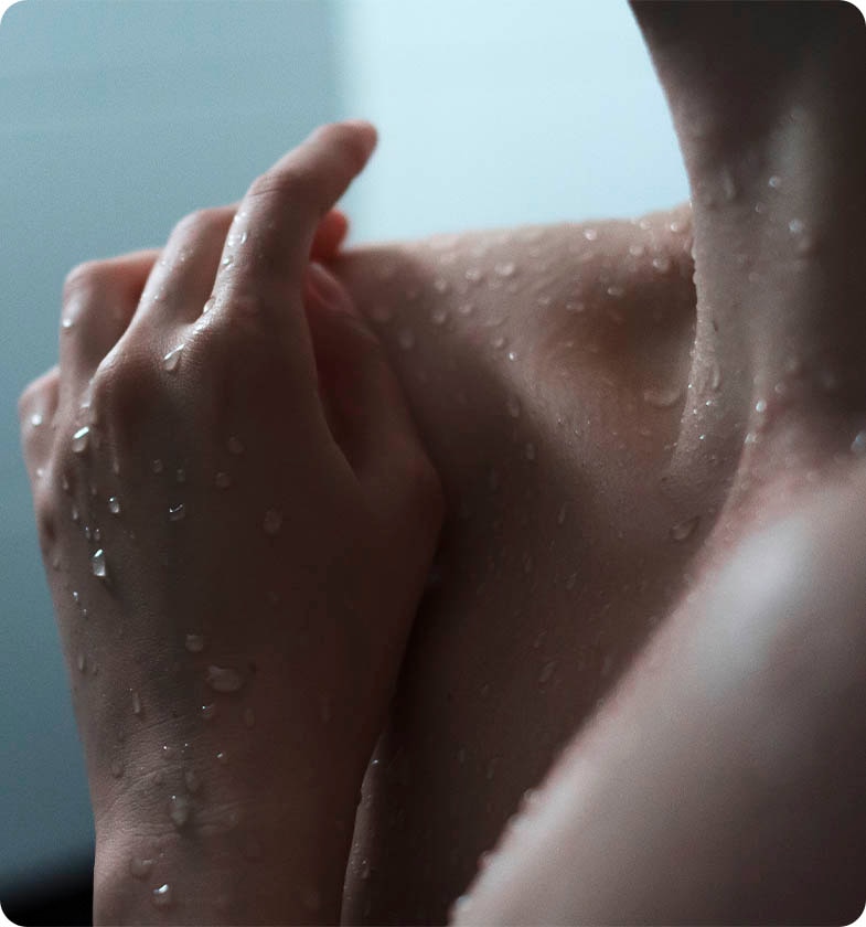 Person is wet with hand feeling the skin of the shoulder