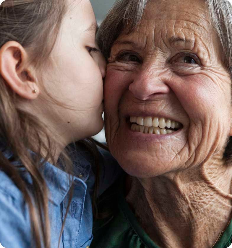 female child kissing grandmother on the cheek