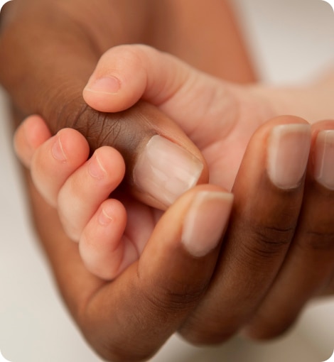 a baby hand holding an adult's hand