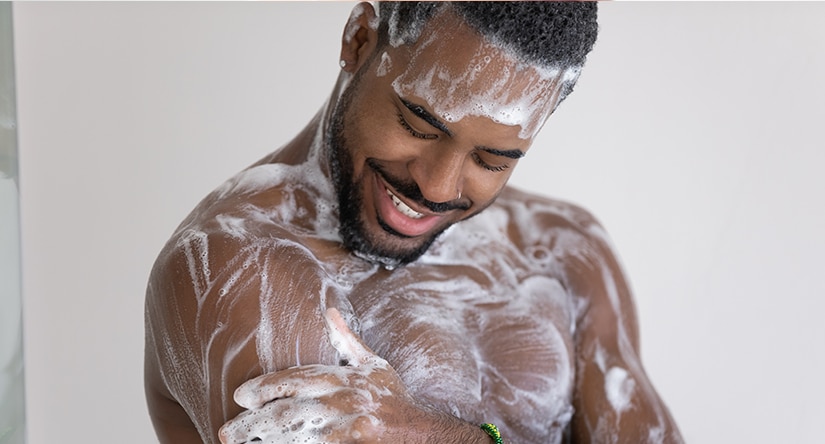 A man showering, practising his daily skincare routine